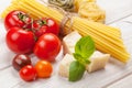 Pasta, tomatoes, basil on wooden table Royalty Free Stock Photo