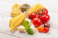 Pasta, tomatoes, basil on wooden table Royalty Free Stock Photo