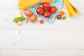 Pasta, tomatoes, basil on wooden table