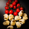 Pasta and tomatoes on a black background Royalty Free Stock Photo