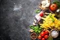 Pasta, tomatoes, cheese, basil and olive oil on black stone tabl Royalty Free Stock Photo