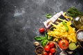 Pasta, tomatoes, cheese, basil and olive oil on black stone tabl Royalty Free Stock Photo