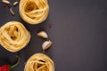 Pasta Top view. Fettuccine nests on a gray background with spices. Hot peppers, fennel seeds and chilli peppers. Flat lay