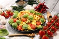 Pasta. tricolor tortellini pasta salad with tomatoes and onions on wood table background Royalty Free Stock Photo