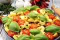 Pasta. tricolor tortellini pasta salad with tomatoes and onions on wood table background Royalty Free Stock Photo