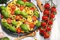 Pasta. tricolor tortellini pasta salad with tomatoes and onions on wood table background Royalty Free Stock Photo