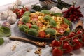 Pasta. tricolor tortellini pasta salad with tomatoes and onions on wood table background Royalty Free Stock Photo