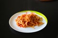 Pasta with vegetable sauce on a white porcelain plate on a black table Royalty Free Stock Photo