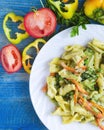 Pasta with vegetables and cheese in a white plate on a blue wooden background Royalty Free Stock Photo