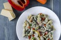 Pasta with vegetables and cheese on a white plate colored background top view Royalty Free Stock Photo