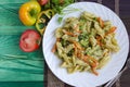 Pasta with vegetables and cheese in a white plate on a green background Royalty Free Stock Photo