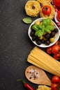 Pasta, vegetables, herbs and spices for Italian food on black background Royalty Free Stock Photo