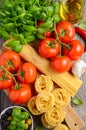 Pasta, vegetables, herbs and spices for Italian food on wooden background Royalty Free Stock Photo