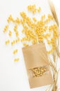 Pasta and wheat spikelets on a white background. Italian food recipes. Top view, flatlay, copy space Royalty Free Stock Photo