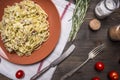 Pasta with zucchini and turkey, ham and herbs on a brown plate on white napkin with vintage cutlery wooden rustic background to Royalty Free Stock Photo