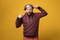 Pastafarianism. Cute man puts a colander on head and points at it with finger. Parody of religion. Studio, yellow Royalty Free Stock Photo