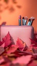 Pastel beauty scene Pink clutch, makeup essentials, and fall foliage Royalty Free Stock Photo