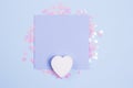 Pastel blue blank card mockup and white wooden heart on pastel blue background with scattered glitter stars. Flat lay background