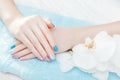 Pastel blue, pink and white manicure with orchid. Body care concept Royalty Free Stock Photo