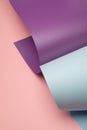 Pastel blue and violet rolled paper on a light pink background. Royalty Free Stock Photo