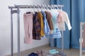 Pastel color children`s clothes in a Row on Open Hanger indoors. Clothes for little ladies hung in the children`s room