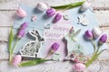 Pastel color easter flat lay with tulips bunnies and greeting text