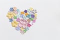 Pastel color paper flower arrange in heart shape on white paper texture background Royalty Free Stock Photo