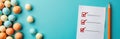 Pastel colored balls are scattered near a checklist and an orange pencil on a bright blue backdrop. This visual suggests Royalty Free Stock Photo