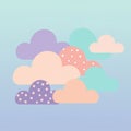 Pastel-colored clouds with polka dot patterns float against a gradient blue to teal Royalty Free Stock Photo