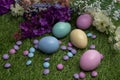 Pastel colored Easter eggs and pastel colored chocolate candy on green grass Royalty Free Stock Photo