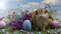 Pastel colored Easter eggs and pastel colored chocolate candy on green grass with Easter bunnies, against colored flowers and blue Royalty Free Stock Photo