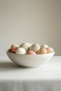 Pastel colored Easter eggs in a white ceramic bowl on a neutral background Royalty Free Stock Photo
