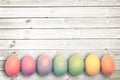 Pastel colored eggs on white wooden planks, easter concept Royalty Free Stock Photo