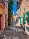 Pastel colored facades of old mediterranean town houses along a narrow paved alley - in Collioure, Pyrenees Orientales, Cote Royalty Free Stock Photo