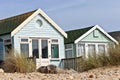 Pastel colored seaside beach huts on sandy dunes Royalty Free Stock Photo