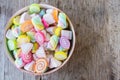 Pastel and colorfu of marshmallow and gummy candy in a wooden bowl on wooden background.