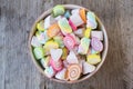 Pastel and colorfu of marshmallow and gummy candy in a wooden bowl on wooden background.