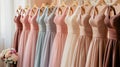 Pastel colorful bridesmaid dresses of all styles hang on the pegs