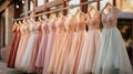 Pastel colorful bridesmaid dresses of all styles hang on the pegs.