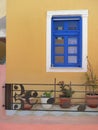 Pastel colors blue window yellow wall music notes fence oia santorini Royalty Free Stock Photo