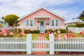 pastel coral seaside cottage with a white picket fence and rose garden Royalty Free Stock Photo