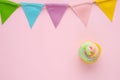 Pastel cupcake and colorful bunting party flag on pink background with copy space for text, birthday, anniversary greeting card b