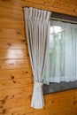 Pastel curtains in rustic wooden room.