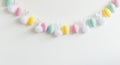 Pastel Easter egg garland with bunny ears and pom-poms on white background Royalty Free Stock Photo