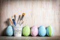 Pastel Easter eggs and brushes in a rustic cup