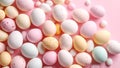 Pastel Easter eggs and candies scattered on a pink background, overhead view. Royalty Free Stock Photo