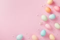 Pastel Easter eggs on pink background top view. Flat lay style