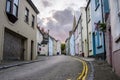 Pastel houses along a deserted cobblestone street at dusk