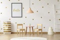 Pastel lamp above table and wooden chairs in white and gold kid` Royalty Free Stock Photo