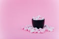 Pastel marshmallow in a cup on a pink background.